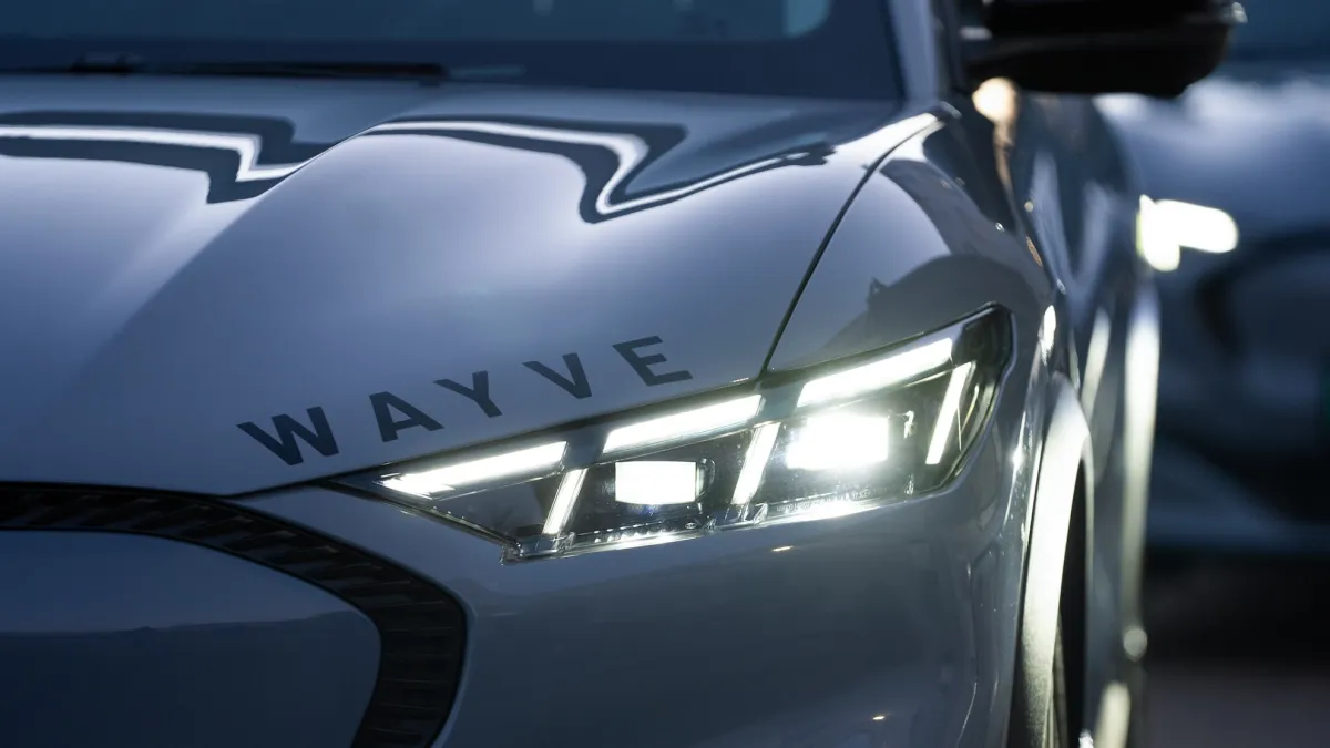 Беспилотный автомобиль Wayve, оснащенный датчиками и камерами, движется по городской улице, демонстрируя технологии искусственного интеллекта.